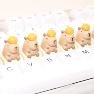 Detailansicht der sitzenden Capybara Tastenkappe mit Mandarine auf dem Kopf