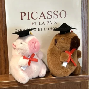 Beide farbvarianten des capybara plüsch schlüsselanhänger mit diplom und abschlussmütze