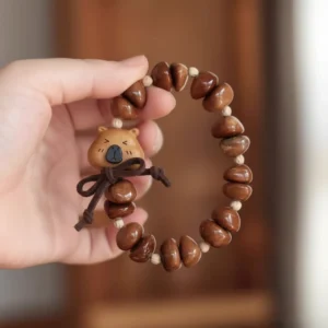 Handgeschnitztes Capybara Armband aus Pfirsichholz mit natürlichen Kuka-Nuss Perlen, Gesamtansicht des Designs