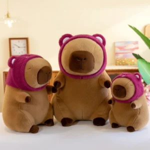 Drei Capybara Kuscheltiere mit Erdbeer-Bären-Kapuze in verschiedenen Größen in einer Reihe