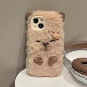 Capybara Plüsch Handyhülle mit Haarclip - Beige flauschige Hülle in Form eines schlafenden Capybara mit gestickten Augen, kleinen braunen Pfoten, gehäkelten Öhrchen und dekorativem Haarclip