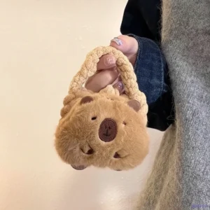 Capybara plüsch mini handtasche portemonnaie in beige als capybara kopf mit weichen griffen, gehalten von einem model