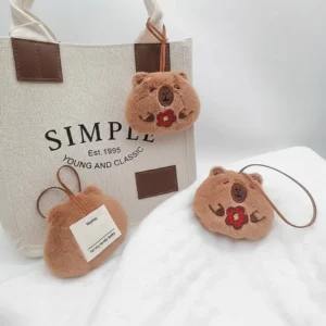 Vorder- und Rückansicht des Capybara Plüsch Namensanhängers mit Glücksblume und beschreibbarem Label