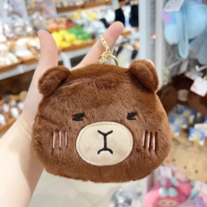 Capybara pluesch portemonnaie schluesselanhaenger in cocoa braun mit gesticktem schlaefrigem gesicht und goldenen clip