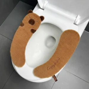 Kuscheliges Capybara Plüsch WC Sitzkissen in Braun liegend auf weißem Hintergrund