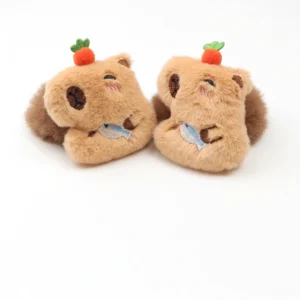 Nahaufnahme von braunem capybara plush haargummi mit winkendem gesicht, möhre auf dem kopf und blauem fisch