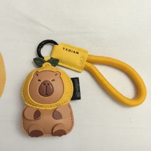 Nahaufnahme von süßem Capybara Schlüsselanhänger aus Kunstleder mit gelber Zitronenhaube und gelbem Seil