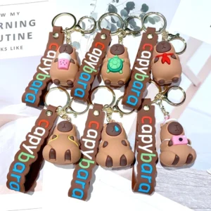 Sammlung von sechs suessen Capybara Schluesselanhaengern aus PVC mit Motiven wie Bubble Tea, Schildkroete und Kamera, mit braunen Baendern mit Capybara Schrift