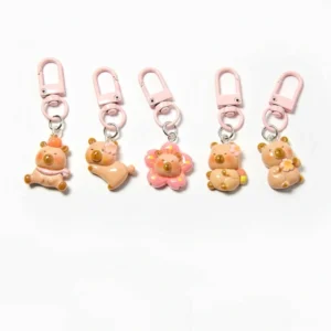 Komplettes 5-teiliges Sakura Capybara Anhänger Set aus Harz mit rosa Kirschblüten-Designs und rosa Karabinerhaken auf weißem Hintergrund