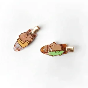 capybara haarspange aus acryl mit plaid muster – detailaufnahme der unterschiedlichen capybara meme motive