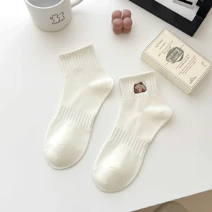 Nahaufnahme einer weißen Unisex Capybara Socke mit niedlicher Stickerei am Bündchen