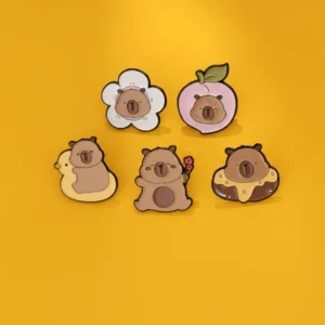 Set aus fünf niedlichen chubby capybara anstecknadeln mit verschiedenen Designs: Pfirsich, Donut, Blume, Entenring und Blume haltend