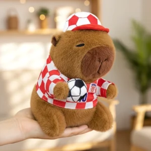 Seitenansicht des weichen Fußball Capybara Stofftieres mit Plüsch-Fußball