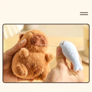 interaktiver capybara plüsch-schlüsselanhänger mit sacabambaspis fisch hängt an einer tasche