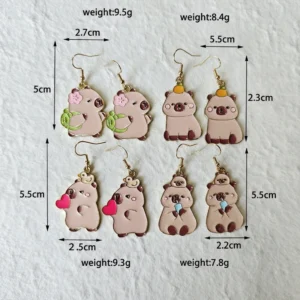 Vier verschiedene kawaii Capybara Emaille Tropfenohrringe mit Designs Schildkrötenrucksack, rotes Herz, Boba Getränk und Orange auf dem Kopf