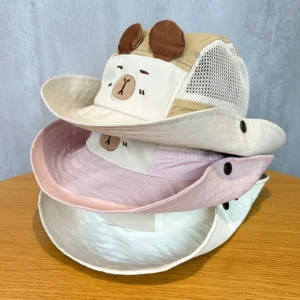 Stapel mit drei Kinder Capybara Fischerhüten in Pink, Beige und Weiß mit Netzseiten und Capybara-Aufnäher