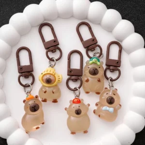 5er Set leuchtende Capybara Taschenanhänger, transluzent bernsteinfarben bei Tag und leuchtend grün im Dunkeln, mit Designs wie Schildkröte, Orange und Kappe