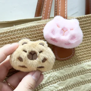 Nahaufnahme weiche flauschige braune und pinke Capybara Anstecknadel mit bestickten Gesichtsdetails