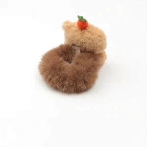 Detailansicht des niedlichen capybara haargummi mit winkeauge und möhre dekor
