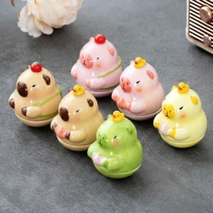 Sammlung von sechs bunten wackelnden Capybara Keramik Mini Figuren, verschiedene Farben mit Erdbeere oder Ente auf dem Kopf