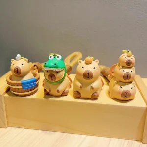 Vier süße 3D Capybara Schlüsselanhänger auf Holzständer, mit Designs Badewanne, Krokodil Verkleidung, Orange auf Kopf und Capybara Stapel