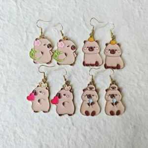 Vier verschiedene kawaii Capybara Emaille Tropfenohrringe mit Designs Schildkrötenrucksack, rotes Herz, Boba Getränk und Orange auf dem Kopf