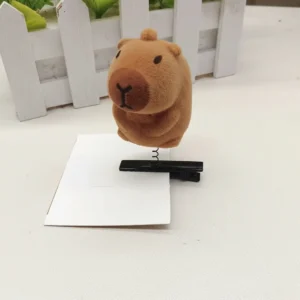 Nahaufnahme der wackelnden flocked Capybara Haarspange mit Feder, Seitenansicht die den Wackelmechanismus zeigt